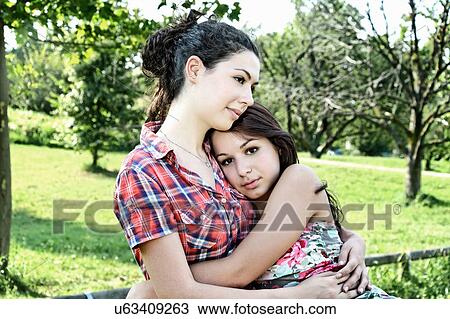 Stock Image - Portrait of two young women hugging. Fotosearch