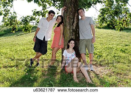 Portrait of young adults next to a tree View Large Photo Image Stock Photo - Portrait of young adults next to a tree. Fotosearch