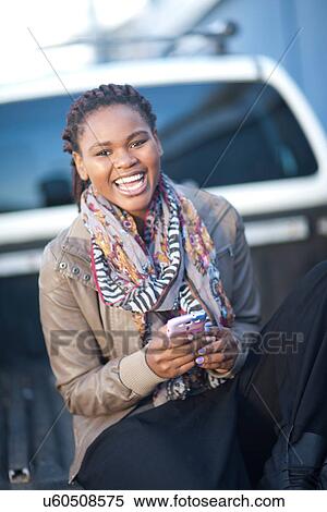 Stock Photography - Portrait of young female sitting on back of pickup truck. Fotosearch