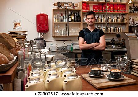 Portrait of young man behind kitchen counter in cafe View Large Photo Image Stock Photo - Portrait of young man behind kitchen counter in cafe. Fotosearch