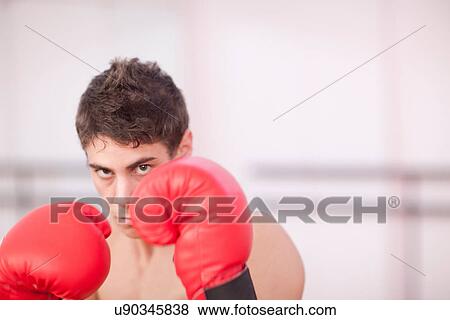 Stock Photo - Portrait of young man in boxing gloves. Fotosearch