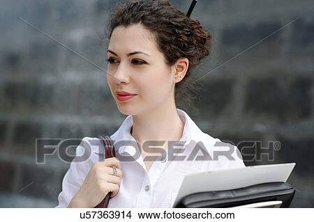 Picture - Portrait of young office worker with files. Fotosearch