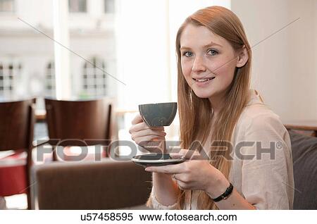 Portrait of young woman drinking coffee in cafe View Large Photo Image Stock Photography - Portrait of young woman drinking coffee in cafe. Fotosearch