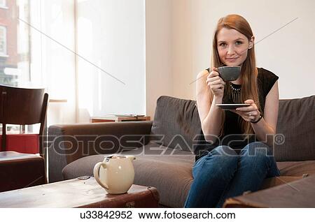Portrait of young woman drinking tea in cafe View Large Photo Image Stock Image - Portrait of young woman drinking tea in cafe. Fotosearch