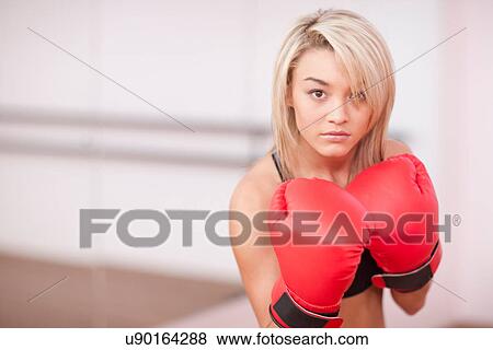 Stock Photo - Portrait of young woman in boxing gloves. Fotosearch