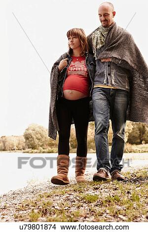 Pregnant woman and partner walking beside river View Large Photo Image Picture - Pregnant woman and partner walking beside river. Fotosearch