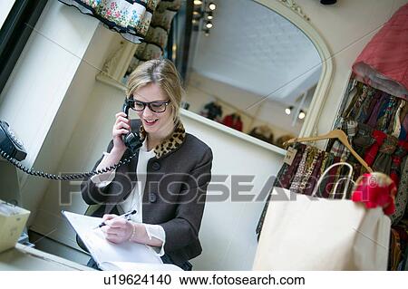 Sales assistant taking phone call View Large Photo Image Stock Image - Sales assistant taking phone call. Fotosearch