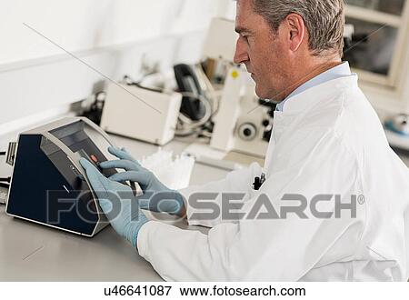 Stock Photo - Scientist using laboratory equipment. Fotosearch