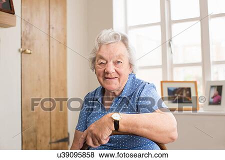 Senior adult woman sitting in room View Large Photo Image Stock Photo - Senior adult woman sitting in room. Fotosearch