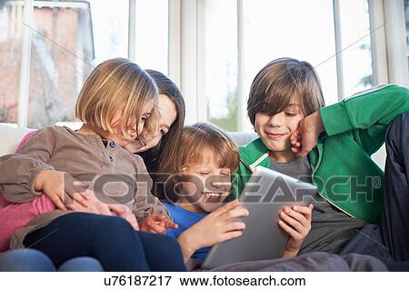 Stock Photo - Siblings using digital tablet together. Fotosearch
