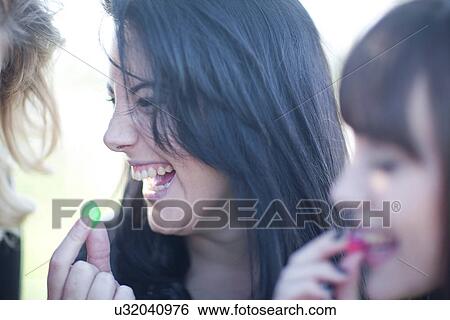 Stock Photograph - Small group of young females sharing sweets. Fotosearch