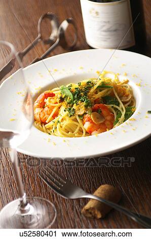 Stock Image - Still life of spaghetti with prawns and garnish. Fotosearch