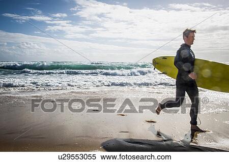 Stock Photography - Surfer running with surfboard. Fotosearch