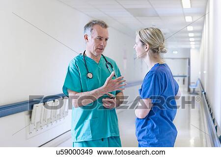Stock Photo - Surgeon and doctor standing in corridor. Fotosearch