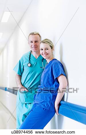Stock Photograph - Surgeon and doctor standing in corridor. Fotosearch