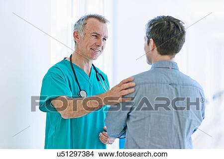 Picture - Surgeon talking to man. Fotosearch