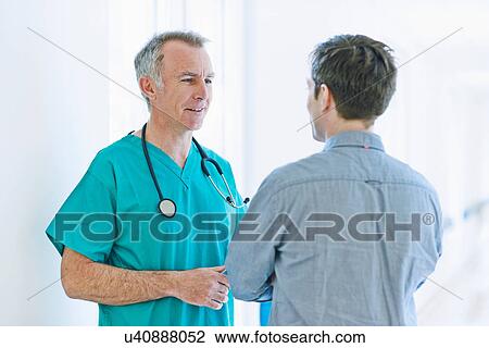 Surgeon talking to man View Large Photo Image Stock Image - Surgeon talking to man. Fotosearch