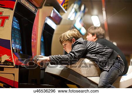Two young brothers playing on driving video games View Large Photo Image Stock Photograph - Two young brothers playing on driving video games. Fotosearch