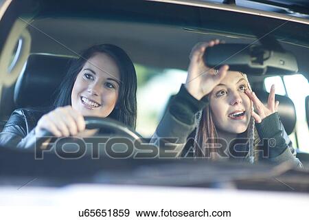 Two young female friends in car View Large Photo Image Stock Photo - Two young female friends in car. Fotosearch
