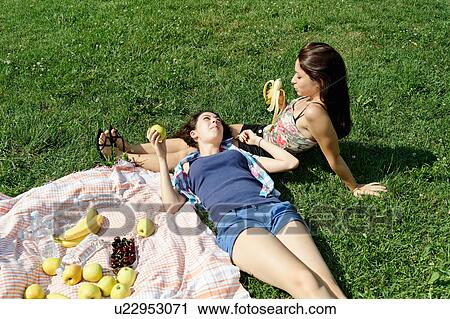 Two young females sharing a picnic View Large Photo Image Stock Image - Two young females sharing a picnic. Fotosearch