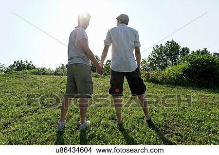 Two young men walking and holding hands View Large Photo Image Picture - Two young men walking and holding hands. Fotosearch
