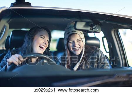 Stock Image - Two young women driving car. Fotosearch