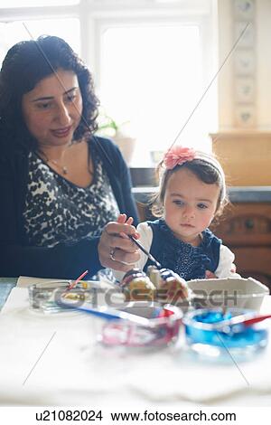 Picture - Woman and girl painting Easter eggs. Fotosearch