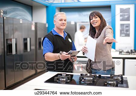 Woman and kitchen appliance salesman in showroom View Large Photo Image Picture - Woman and kitchen appliance salesman in showroom. Fotosearch