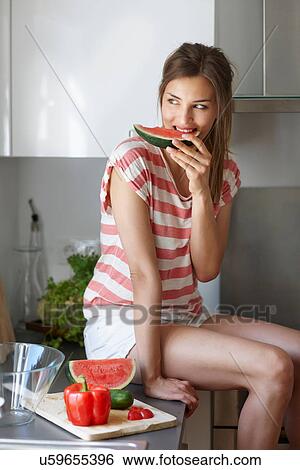 Woman biting slice of watermelon View Large Photo Image Stock Photograph - Woman biting slice of watermelon. Fotosearch