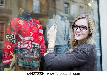 Woman cleaning window of clothes shop View Large Photo Image Picture - Woman cleaning window of clothes shop. Fotosearch