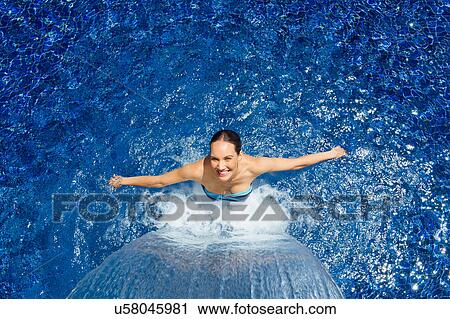 Woman cooling down under waterfall in pool View Large Photo Image Stock Image - Woman cooling down under waterfall in pool. Fotosearch