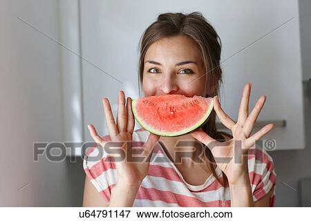 Woman covering mouth with slice of watermelon View Large Photo Image Stock Photo - Woman covering mouth with slice of watermelon. Fotosearch