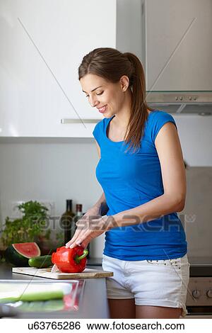 Woman cutting red pepper View Large Photo Image Stock Photograph - Woman cutting red pepper. Fotosearch