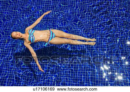 Woman floating in pool View Large Photo Image Stock Photo - Woman floating in pool. Fotosearch