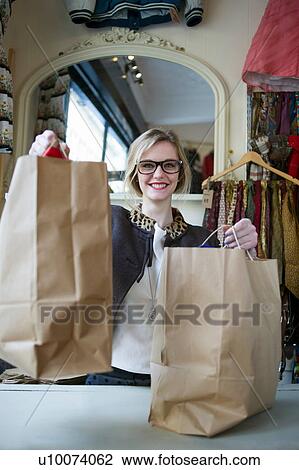 Stock Image - Woman holding bags of shopping. Fotosearch