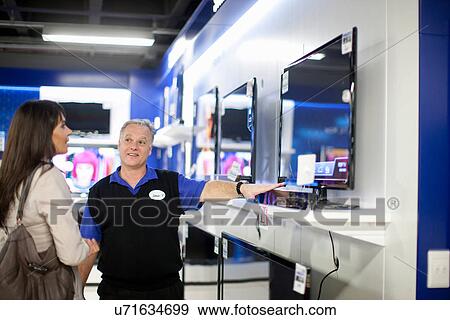 Woman looking at flat screen TV in showroom View Large Photo Image Stock Photo - Woman looking at flat screen TV in showroom. Fotosearch