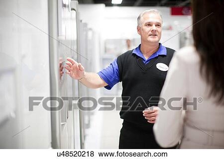 Woman looking at refrigerator in showroom View Large Photo Image Stock Photo - Woman looking at refrigerator in showroom. Fotosearch