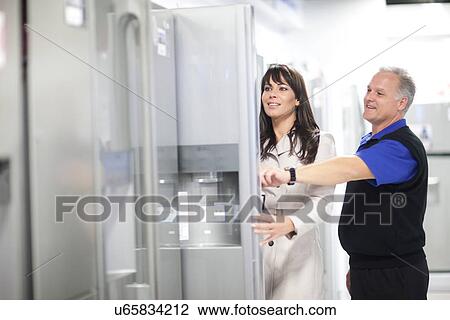 Woman looking at refrigerators in showroom View Large Photo Image Stock Image - Woman looking at refrigerators in showroom. Fotosearch