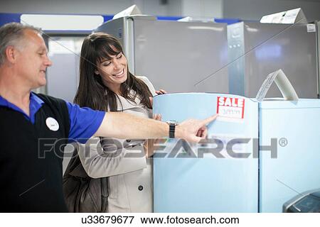 Woman looking at sale appliances in showroom View Large Photo Image Stock Photo - Woman looking at sale appliances in showroom. Fotosearch