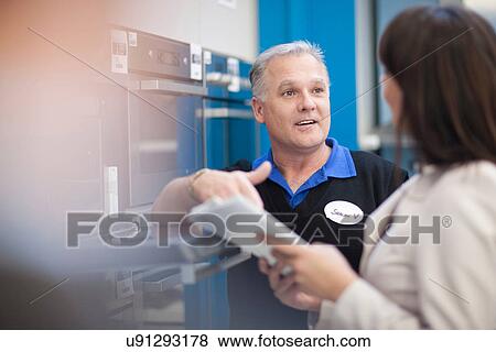 Woman negotiating with salesman in showroom View Large Photo Image Stock Photo - Woman negotiating with salesman in showroom. Fotosearch