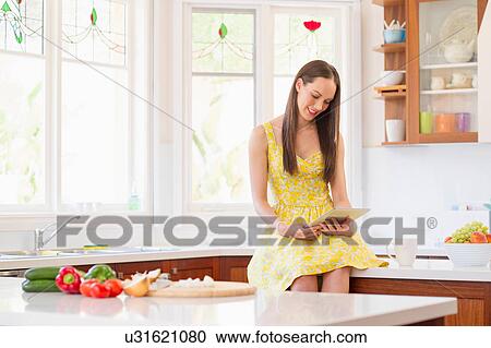 Stock Image - Woman preparing vegetables for meal. Fotosearch