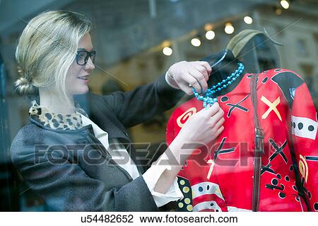 Woman putting necklace on shop dummy View Large Photo Image Stock Image - Woman putting necklace on shop dummy. Fotosearch