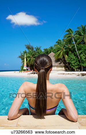 Stock Image - Woman relaxing at the beach. Fotosearch