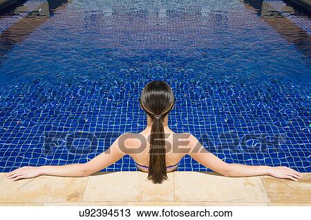 Stock Image - Woman relaxing in pool. Fotosearch