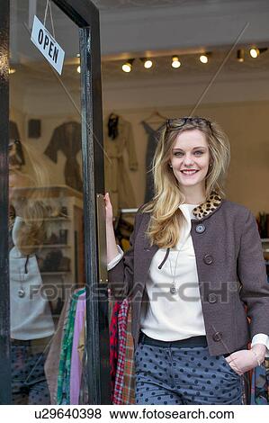 Woman standing in doorway of clothes shop View Large Photo Image Stock Photo - Woman standing in doorway of clothes shop. Fotosearch