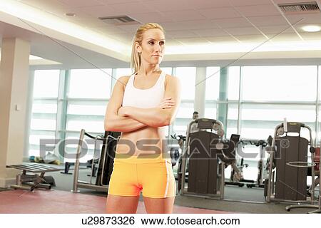 Stock Photograph - Woman standing in gymnasium. Fotosearch