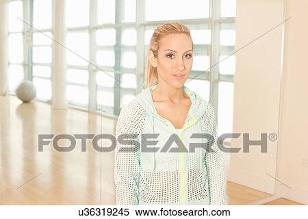 Stock Photography - Woman standing in gymnasium. Fotosearch