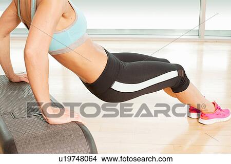 Picture - Woman stretching on step. Fotosearch