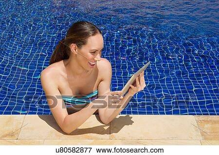 Woman using digital tablet in pool View Large Photo Image Stock Photo - Woman using digital tablet in pool. Fotosearch