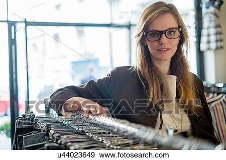 Women leaning on clothes rail View Large Photo Image Stock Photo - Women leaning on clothes rail. Fotosearch